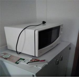 un four micro-ondes installé au-dessus d'un comptoir dans l'établissement Chambre cosy calme proche aéroport, Groupama Stadium, CNPE BUGEY, Eurexpo, à Chavanoz