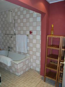 a bathroom with a tub and a pink wall at Ferienhaus Mauseloch in Kaub