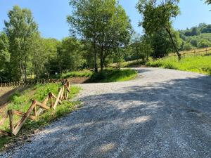 a dirt road with a wooden fence on the side at Bieszczadzka Samotnia in Cisna