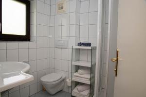 a white bathroom with a toilet and a sink at Villa Mayr in Villach