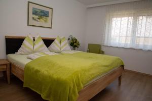 1 dormitorio con 1 cama grande con manta amarilla en Villa Mayr, en Villach