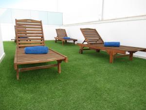 dos sillas y dos bancos sentados en el césped en NÁUTICO Suites, by Comfortable Luxury - Adults Only en Corralejo