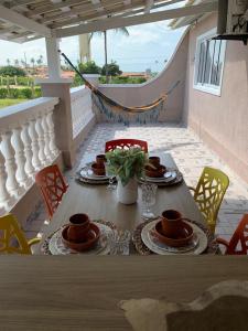 une table avec des tasses et des soucoupes sur un balcon dans l'établissement Casa Porto Fiore, à Paripueira