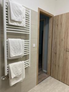 łazienka z białymi ręcznikami wiszącymi na ścianie w obiekcie Paskom Apartmanház w mieście Nyergesújfalu +37 zdjęć