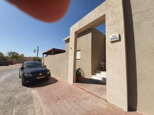 Beʼer Ora的住宿－חדר במדבר，停在房子外的一辆黑色汽车