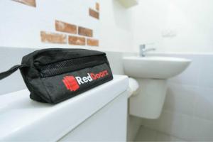 un sac noir assis sur un comptoir dans une salle de bains dans l'établissement RedDoorz Plus near Nagoya Hill Batam 6, à Bumiayu