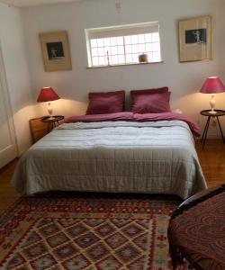 een slaapkamer met een groot bed met paarse kussens bij Eikenburg B&B in Eindhoven