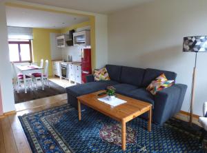 a living room with a blue couch and a table at Ferienwohnung Högel Großjena in Naumburg