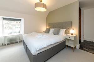 Un dormitorio con una gran cama blanca y una ventana en Lews Castle, en Stornoway