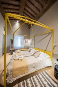 Cette chambre comprend un grand lit avec un cadre jaune. dans l'établissement Podere Gonzaga, à Pienza