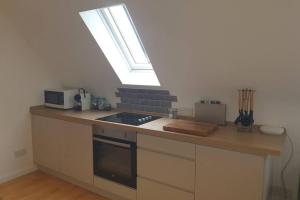 a kitchen with a counter with a stove and a window at Fieldside Barn in Long Wittenham