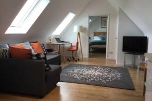 a living room with a couch and a television at Fieldside Barn in Long Wittenham