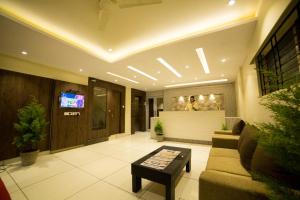 a lobby with a couch and a table at Hotel Plaza Heights in Bangalore