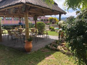 a pavilion with tables and chairs in a garden at Estación del Lago in Potrero de los Funes