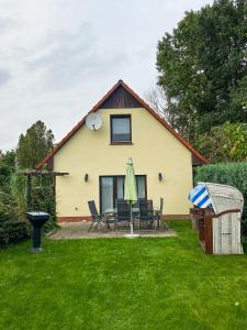 a house with a table and chairs in a yard at Nordwind Sjut in Warnow