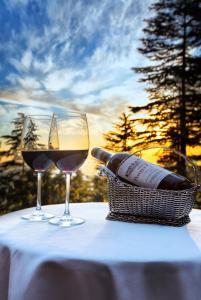 Wildflower Hall, An Oberoi Resort, Shimla في شيملا: كأسين من النبيذ الأحمر يجلسون على الطاولة