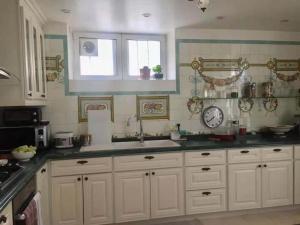 a kitchen with white cabinets and a sink and a window at Appart luxueux 3+1 pcs avec jardin à 3 km de Paris in Sèvres