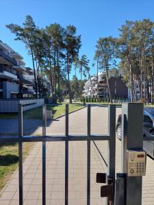 a fence with a parking meter next to a street at Apartment LILY - Baltic Park Pogorzelica in Pogorzelica