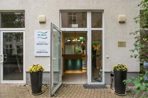 einen Eingang zu einem Gebäude mit einer Tür und Blumen in der Unterkunft Nu Wave Hotel Berlin in Berlin