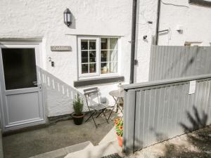 a white house with a table and a door at Cuddfan in Llangollen