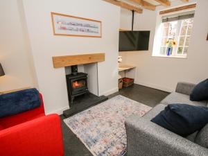 a living room with a fireplace and a tv at Cuddfan in Llangollen