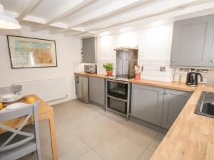 a large kitchen with stainless steel appliances and a table at Cuddfan in Llangollen