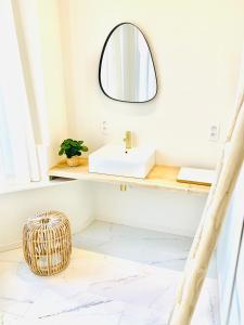 W łazience znajduje się umywalka i lustro. w obiekcie Rooms & Loft De Post w mieście Gavere