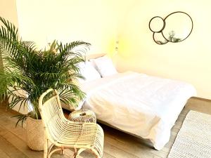 a bedroom with a bed and a chair and plants at Rooms & Loft De Post in Gavere