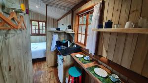 a kitchen with a sink and a bed in a cabin at Itaipava, Cabana No Alto do Vale in Itaipava