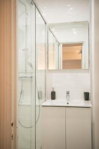 bagno con doccia in vetro e lavandino di Alerte bien rare ! Studio avec terrasse a Parigi