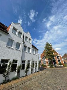 弗倫斯堡的住宿－Hotel Xenia Flensburg，白色的建筑,旁边是植物