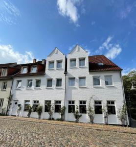 a white building with a red roof at Hotel Xenia Flensburg in Flensburg