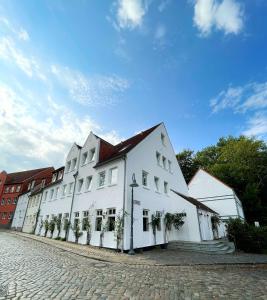 un gran edificio blanco al lado de una calle en Hotel Xenia Flensburg, en Flensburg