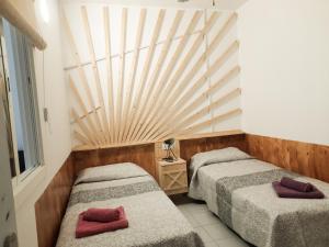 two beds in a room with a wooden ceiling at Bimbache Home in Frontera