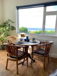 a table and chairs with a table and a window at Zepher Apartment in Doolin