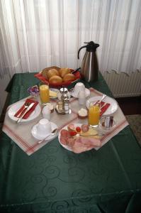 a table with a green table cloth with a plate of food at Pension Zur Sonne in Mansfeld