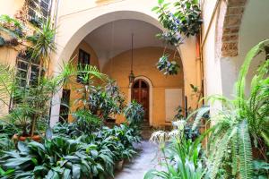 einen Innenhof mit Pflanzen vor einem Gebäude in der Unterkunft Le stanze di Bianca in Palermo
