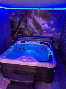 een jacuzzi in een kamer met een palmboom bij L évasion secrète in Quarouble