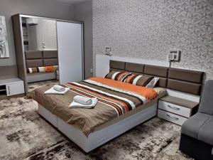 a bedroom with a bed and a mirror and a chair at Apartment Ani in Veliko Tŭrnovo