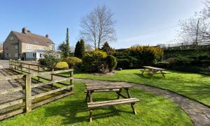 two picnic tables in the grass next to a fence at The New Inn in Pickering