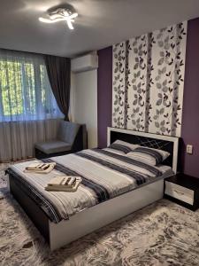 a bedroom with a large bed and a chair at Apartment Ani in Veliko Tŭrnovo