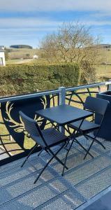 un tavolo e 2 sedie seduti su un balcone di Le Cerf1 a Bertogne