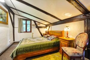 a bedroom with a bed and a table and a chair at Chata Kataryniarza in Karłów