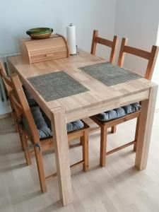 een houten eettafel met 2 stoelen en een kom bovenop bij Ferienwohnung Roder in Marburg an der Lahn