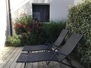 2 chaises et une table sur une terrasse fleurie dans l'établissement Sci Ti Korelo, à Guidel