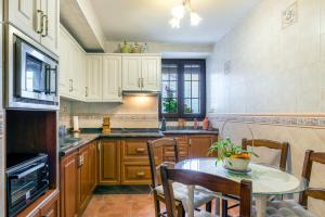 カピレイラにあるCasa abuela pilarのキッチン(木製キャビネット、テーブル、椅子付)