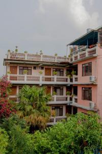 un edificio de apartamentos con balcones y una palmera en Hotel Metropolitan Kantipur, en Katmandú