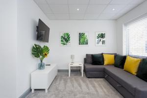 a living room with a gray couch and yellow pillows at Sovereign Gate 1 - 2 double bedroom apartment in Portsmouth City Centre in Portsmouth