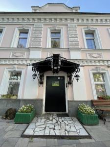 um edifício com uma porta preta e duas plantas em Mila Guest House em Moscovo