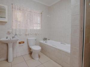 y baño con aseo, bañera y lavamanos. en Beesdam Guesthouse, en Potchefstroom